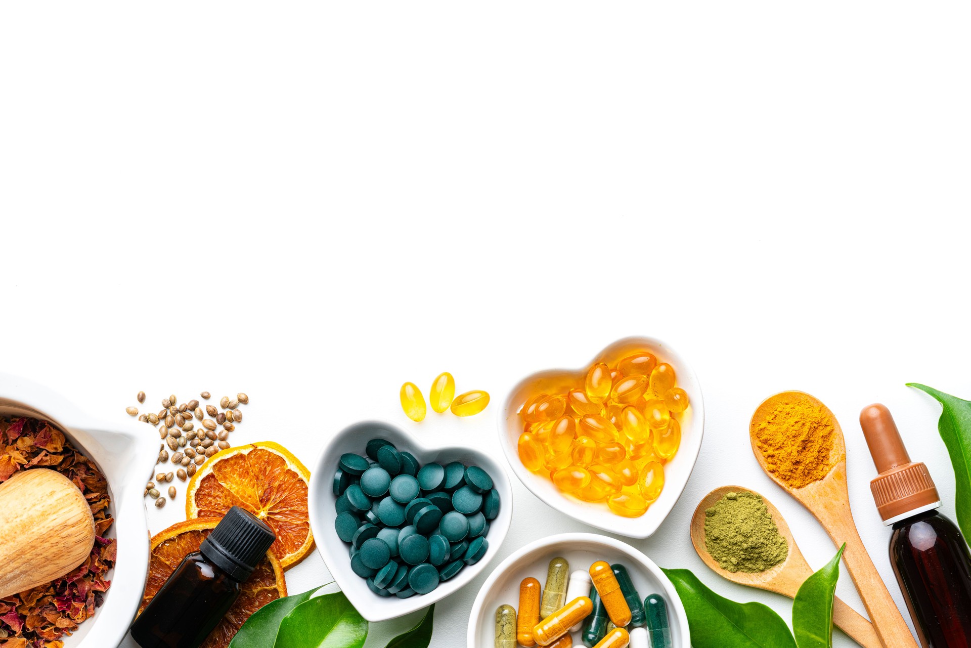 Nutritional supplements and natural vitamins or healthy eating and dieting. Lower border on white background with copy space. Healthcare or alternative medicine. Spirulina pills and Omega-3 capsules